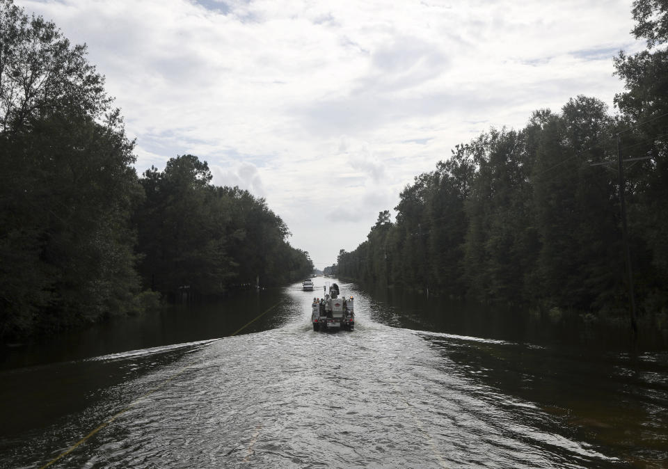 An Entergy truck drives through floodwater from the remnants of Tropical Storm Imelda on Friday, Sept. 20, 2019, in the Mauriceville, Texas, area. Floodwaters are starting to recede in most of the Houston area after the remnants of Tropical Storm Imelda flooded parts of Texas, ( Jon Shapley/Houston Chronicle via AP)