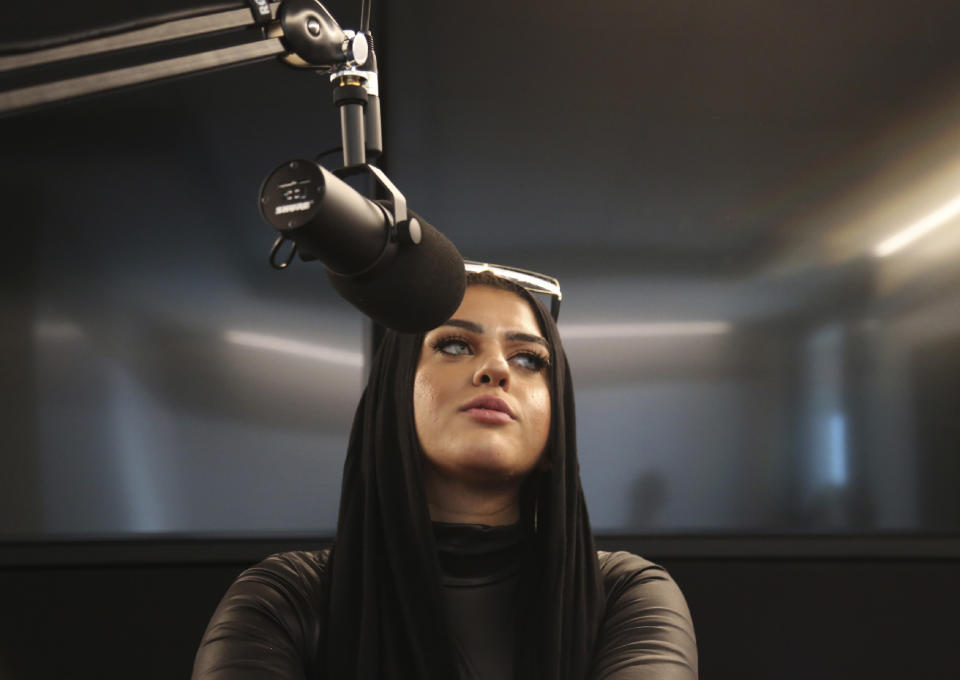 FILE - In this Dec. 19, 2019 file photo, Amani Al-Khatahtbeh, founder of Muslimgirl.com, sits in a Spotify recording studio as she and and a cohost record a pilot for her new potential podcast, in New York. After recently being threatened with Islamophobic and violent comments, the 27-year-old New Jersey congressional candidate was publicly supported by dozens of female leaders, including Congresswomen Rashida Tlaib and Ilhan Omar. (AP Photo/Jessie Wardarski, File)