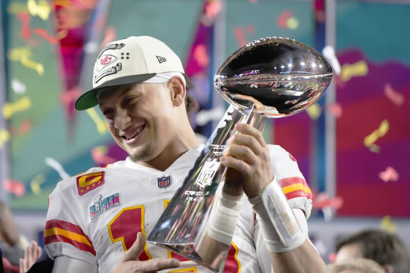 El quarterback Patrick Mahomes (15) de los Chiefs de Kansas City sostiene el trofeo.