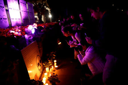 People meet in front of a floral offering for the victims who died in the September 19 earthquake as part of Day of the Dead celebrations at Mexico park in Mexico City, Mexico, November 1, 2017. REUTERS/Edgard Garrido