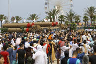 The crowd watches army vehicles during a military parade to mark the 60th anniversary of Algeria's independence, Tuesday, July 5, 2022 in Algiers. Algeria is celebrating 60 years of independence from France with nationwide ceremonies, a pardon of 14,000 prisoners and its first military parade in years. (AP Photo/Anis Belghoul)