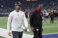 San Francisco 49ers head coach Kyle Shanahan, left, walks off the field with vice president & senior advisor to the general manager and former linebacker Keena Turner after the 49ers defeated the Dallas Cowboys in an NFL wild-card playoff football game in Arlington, Texas, Sunday, Jan. 16, 2022. (AP Photo/Roger Steinman)