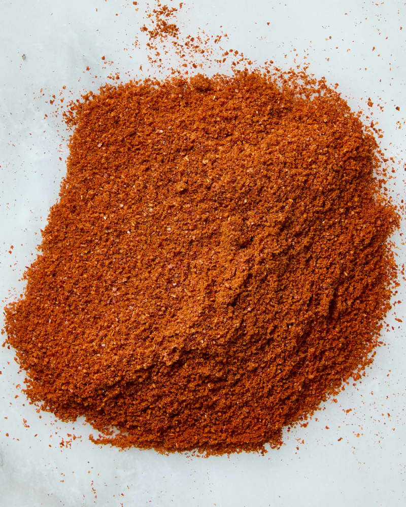 overhead shot of a pile of Hungarian paprika on a white marble surface.