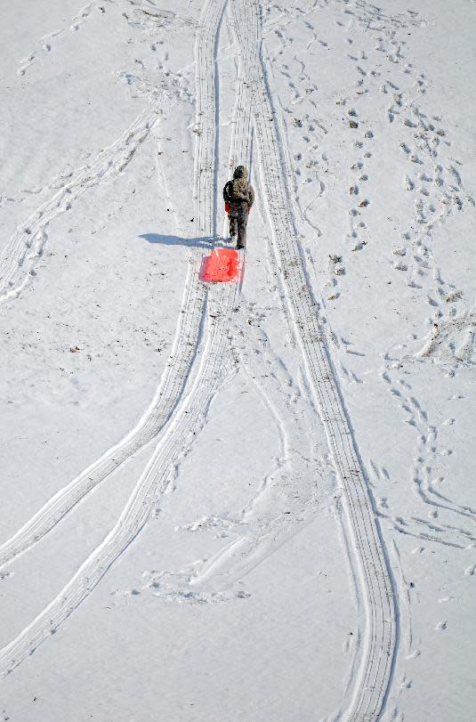 Logan Dixon, 9, trudges back up the hill as he and family members sled at the Henderson Municipal Golf Course in Henderson, Ky Monday morning, February 3, 2014. Henderson County received 1-3 inches of snow over night, prompting schools to be cancelled. Road conditions shaped up quickly and were easily passable by mid-morning. (AP Photo/The Gleaner, Darrin Phegley)