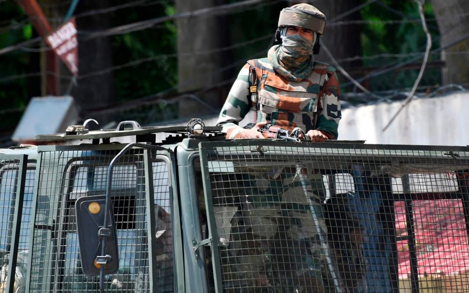 An Indian army soldier stands alert in a truck while patrolling Srinagar - AFP