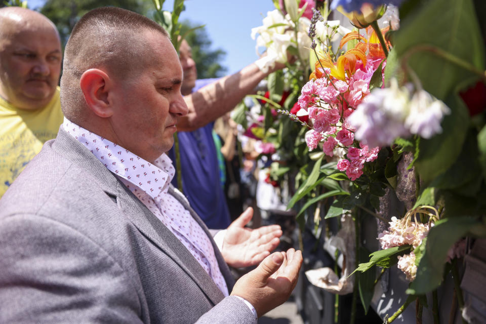 Adel Sabanovic, a Srebrenica survivor prays in Sarajevo, Bosnia, Sunday, July 9, 2023 next to a truck carrying 30 coffins with remains of the recently identified victims of the 1995 Srebrenica genocide. So far, the remains of more than 6,600 people have been found and buried at a vast and ever-expanding memorial cemetery in Potocari, outside Srebrenica. (AP Photo/Armin Durgut)