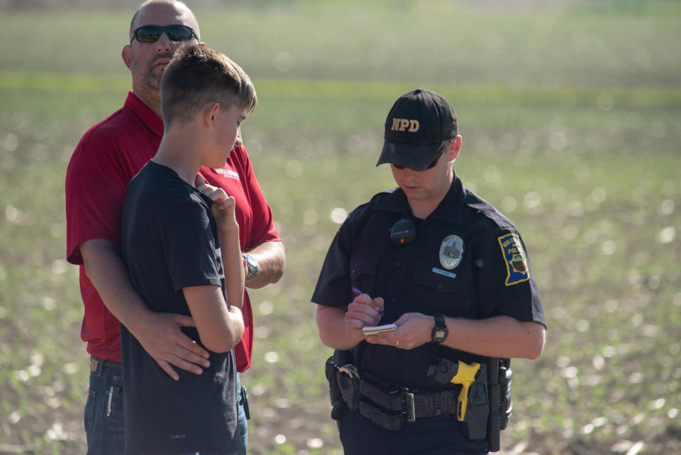A police officer interviews a student and adult.
