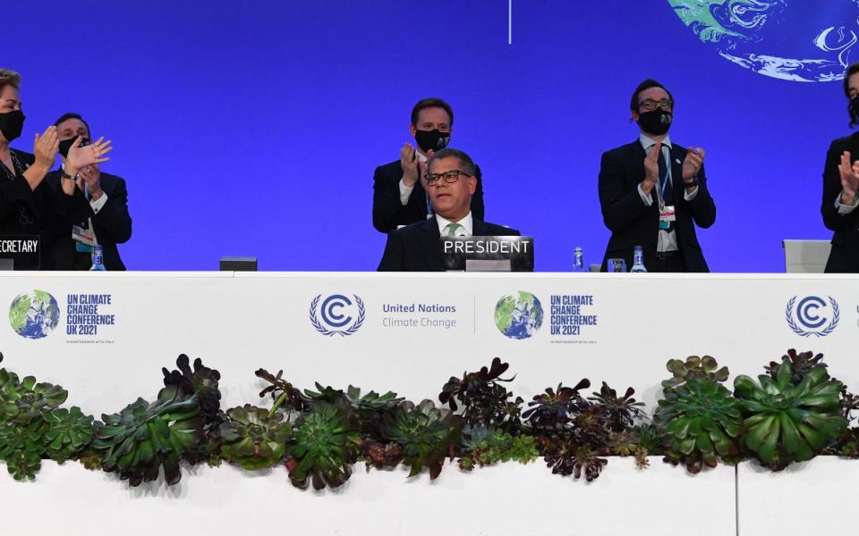 Alok Sharma, centre, Britain's President for Cop26, receives an ovation as he makes his concluding remarks at the conference - Paul Ellis/AFP via Getty Images