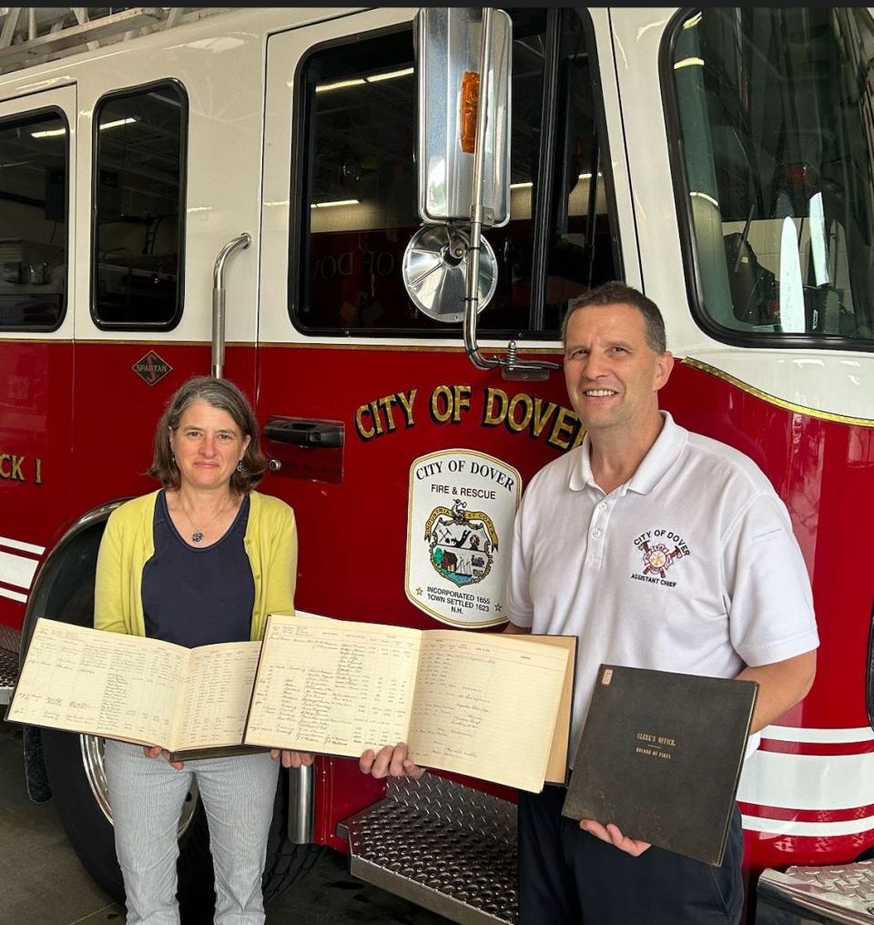 Denise Lafrance, Dover Chief Librarian and Dover Assistant Fire Chief David Hanna with historical logs from the Dover Fire Department.