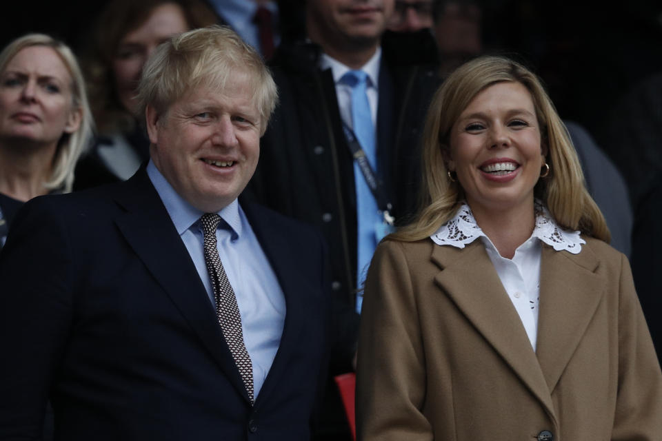 Britain's Prime Minister Boris Johnson (L) with his partner Carrie Symonds attend the Six Nations international rugby union match between England and Wales at the Twickenham, west London, on March 7, 2020. (Photo by Adrian DENNIS / AFP) (Photo by ADRIAN DENNIS/AFP via Getty Images)