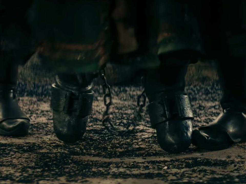 bumi's feat, clad in metal boots that are chained together at the ankles