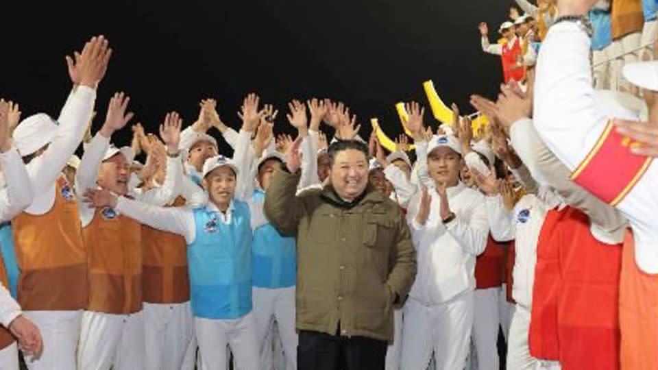 North Korean leader Kim Jong Un celebrates Tuesday night's satellite launch with workers in an image provided by state-run media. - Rodong Sinmun