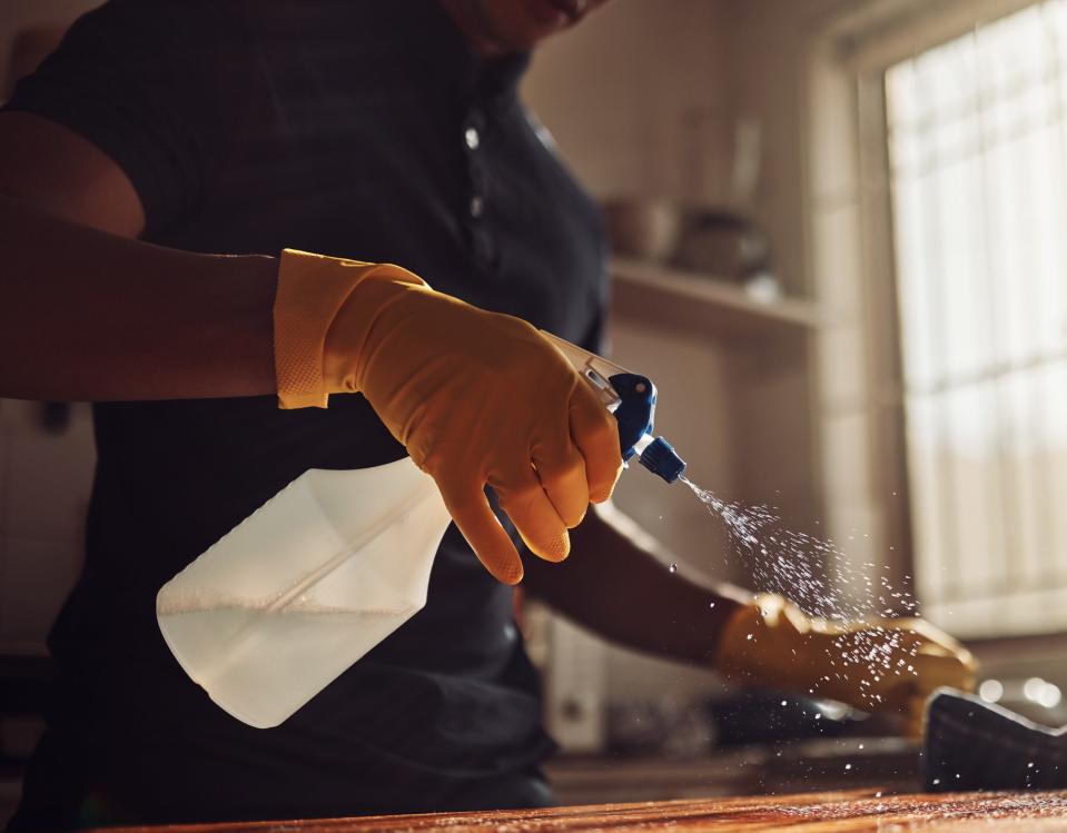 spraying kitchen spray on counter