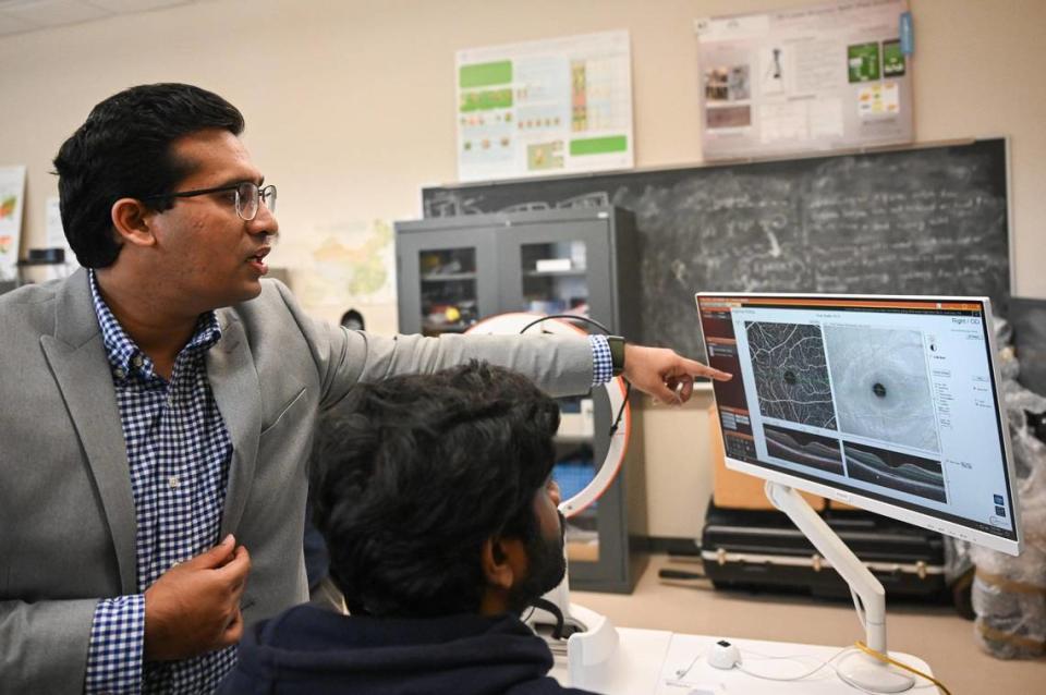 Minjah Alam, left, and Ph.D. student Rashadul Hasan Badhon talk about a retinal scan Thursday in the lab at UNC Charlotte's electrical and computer engineering department. The lab is leading a multi-institutional research effort using AI models.
