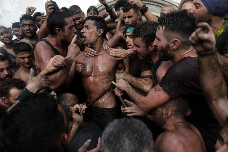 In this photo taken on Friday, Sept. 6, 2019, people celebrate during the traditional festivities of the Cascamorras festival in Baza, Spain. During the Cascamorras Festival, and according to an ancient tradition, participants throw black paint over each other for several hours every September 6 in the small town of Baza, in the southern province of Granada. The "Cascamorras" represents a thief who attempted to steal a religious image from a local church. People try to stop him, chasing him and throwing black paint as they run through the streets. (AP Photo/Manu Fernandez)