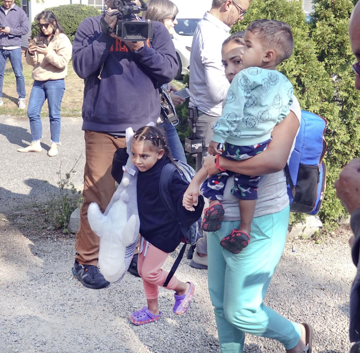 An immigrant family makes their way to the bus transporting from St. Andrews in Edgartown, Mass., to Vineyard Haven and the ferry to Woods Hole, Friday, Sept. 16, 2022. 