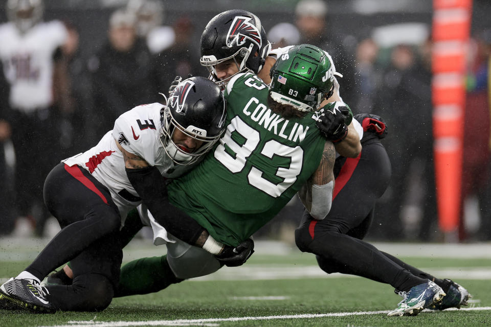 Atlanta Falcons safety Jessie Bates III (3) and linebacker Kaden Elliss (55) tackle New York Jets tight end Tyler Conklin (83) during the second quarter of an NFL football game, Sunday, Dec. 3, 2023, in East Rutherford, N.J. (AP Photo/Adam Hunger)