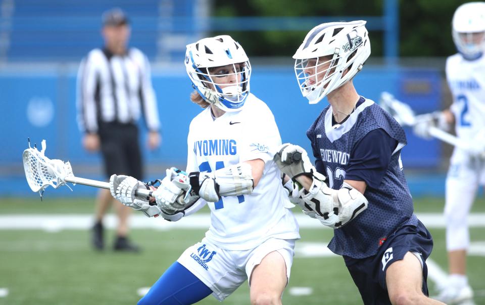 Edgewood senior Connor Ballantyne (22) closely guards Wyoming junior Gabe Scruggs (14) during Wyoming's 10-8 win over Edgewood in the second round of the OHSAA Division II boys lacrosse tournament May 16, 2024.