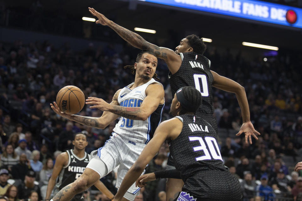 Sacramento Kings guard Malik Monk (0) defends against Orlando Magic guard Cole Anthony (50) who looks to pass in the first quarter in an NBA basketball game in Sacramento, Calif., Monday, Jan. 9, 2023. (AP Photo/José Luis Villegas)