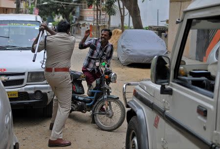 Police stop a man during a curfew in Bengaluru, India, September 13, 2016. REUTERS/Abhishek N. Chinnappa/File Photo