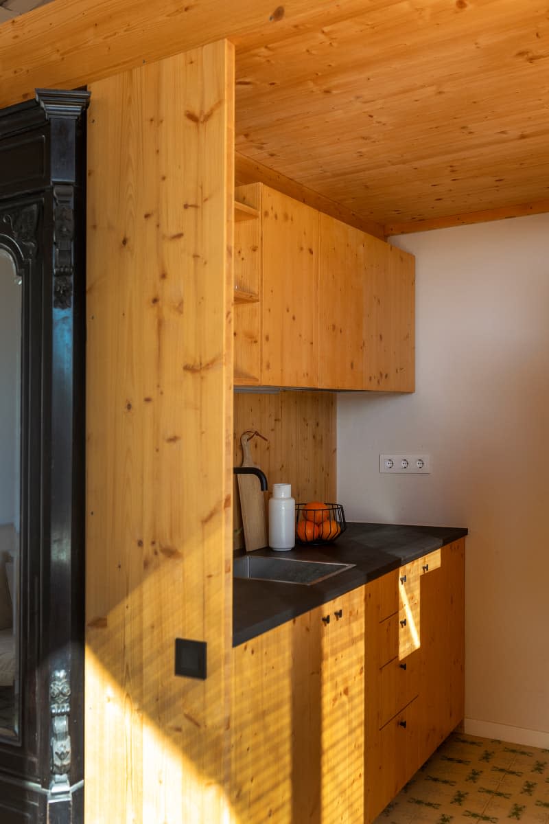 Wood kitchen with black countertop and tile floor