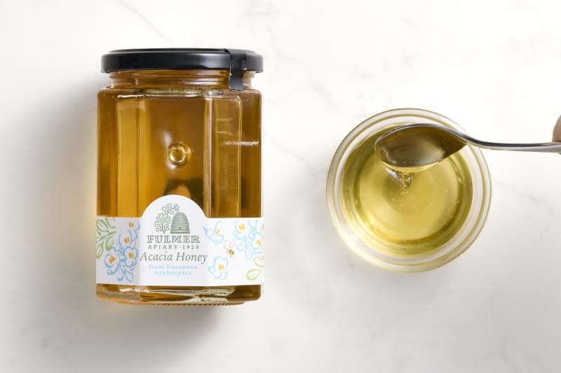 overhead shot of Fulmer Acacia Honey in a bottle, and some in a small glass bowl to the right