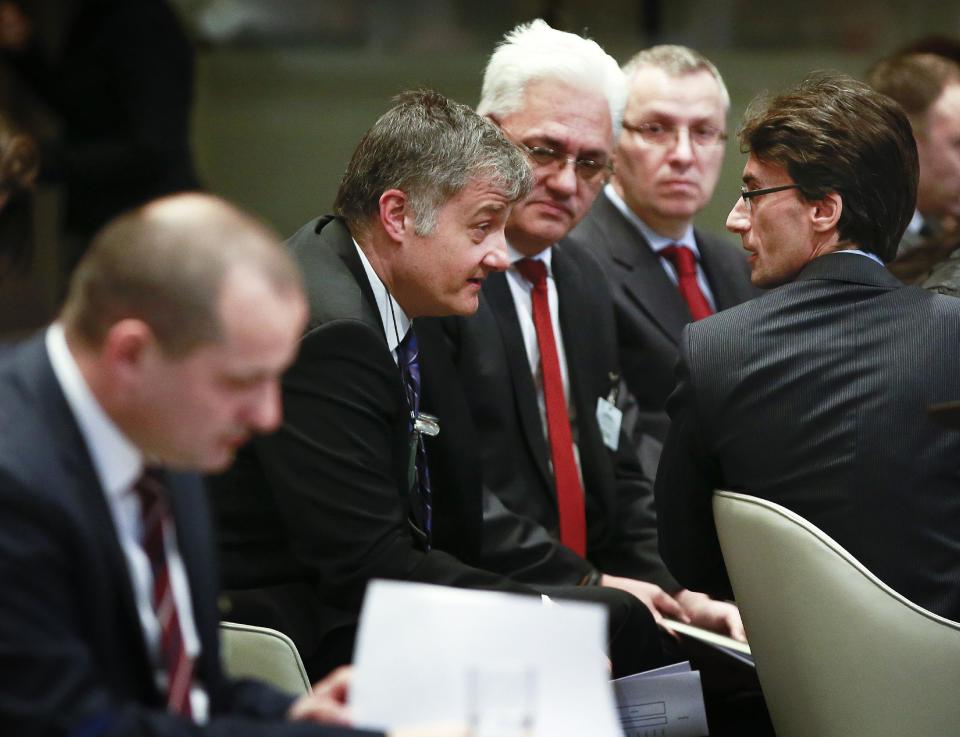 Members of the Serbian delegation Petar Vico, second left and Sasa Obradovic, right, and Croatian Minister Orsat Miljenic, left, await the start of public hearings at the International Court of Justice (ICJ) in The Hague, Netherlands, Monday, March 3, 2014. Croatia is accusing Serbia of genocide during fighting in the early 1990's as the former Yugoslavia shattered in spasms of ethnic violence, in a case at the United Nations' highest court that highlights lingering animosity in the region. Croatia is asking the ICJ to declare that Serbia breached the 1948 Genocide Convention when forces from the former Federal Republic of Yugoslavia attempted to drive Croats out of large swaths of the country after Zagreb declared independence in 1991. (AP Photo/Jiri Buller)