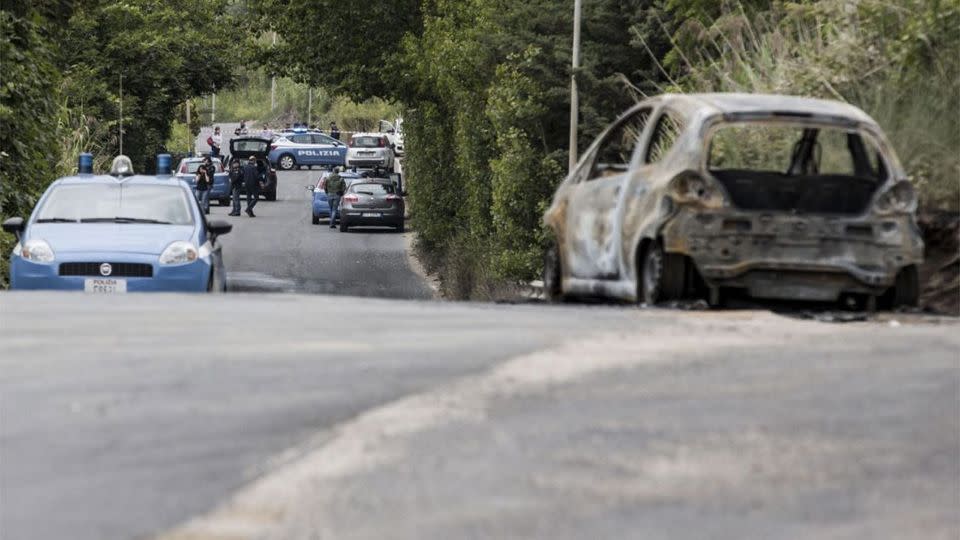 The burned car belonging to slain 22-year-old student Sara Di Pietrantonio is seen along a street in the outskirts of Rome. Photo: AP