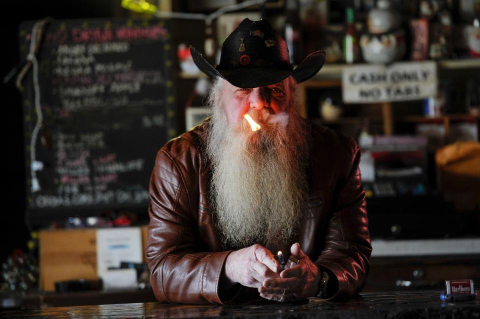 Denzel Irwin, aka Santa, lights his cigarette behind the bar at Santa's Pub on Thursday,  Dec.15, 2016, in Nashville, Tenn.