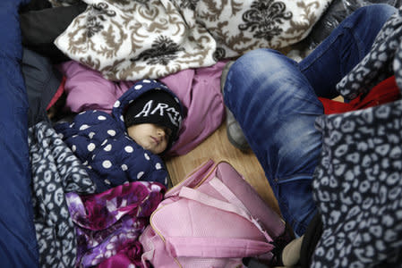 A child sleeps inside a registration camp for migrants in Presevo, Serbia, January 20, 2016. REUTERS/Marko Djurica