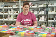 In this Tuesday, Aug. 13, 2019, photo Elizabeth Butts, owner of Sprinkle Pop, a company based in Houston that makes upscale sprinkles for bakers, poses for a photo inside her business in Houston. Butts is building out and equipping a 10,000 foot facility for storage and shipping. She's reinvesting the company's profits rather than seeking investors, which will make it easier for her to run the company, but she also doesn't want to burden her company with debt. (AP Photo/David J. Phillip)