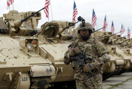 A member of the U.S. mechanized infantry company form 1st Brigade, 3rd Infantry Division walks past Bradley infantry fighting vehicles ahead an official opening ceremony of the joint U.S.-Georgian exercise Noble Partner 2015 at the Vaziani training area outside Tbilisi, Georgia, May 11, 2015. REUTERS/David Mdzinarishvili