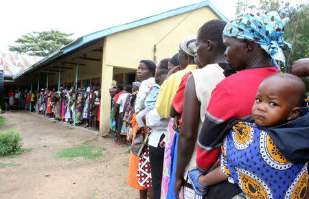 A woman carries her child as she queues to cast her ballot during the Orange Democratic Movement (ODM) party primary at the Jomo Kenyatta sports grounds in the Kenya's west city of Kisumu April 25, 2017. REUTERS/Moses Eshiwani