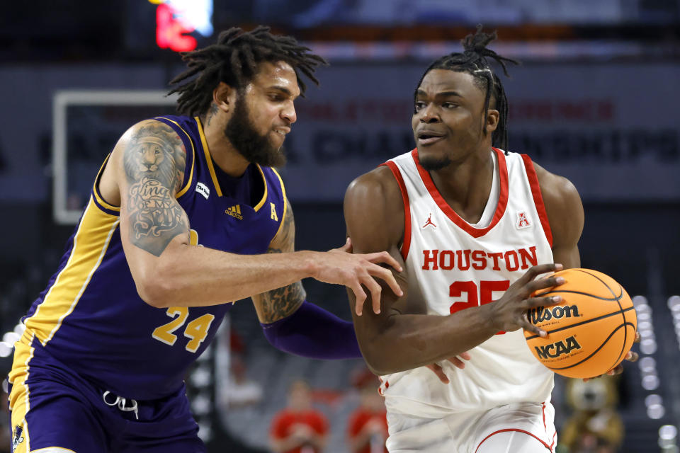 Houston forward Jarace Walker (25) goes to the basket as East Carolina center Ludgy Debaut (24) defends during the first half of an NCAA college basketball game in the quarterfinals of the American Athletic Conference Tournament, Friday, March 10, 2023, in Fort Worth, Texas. (AP Photo/Ron Jenkins)