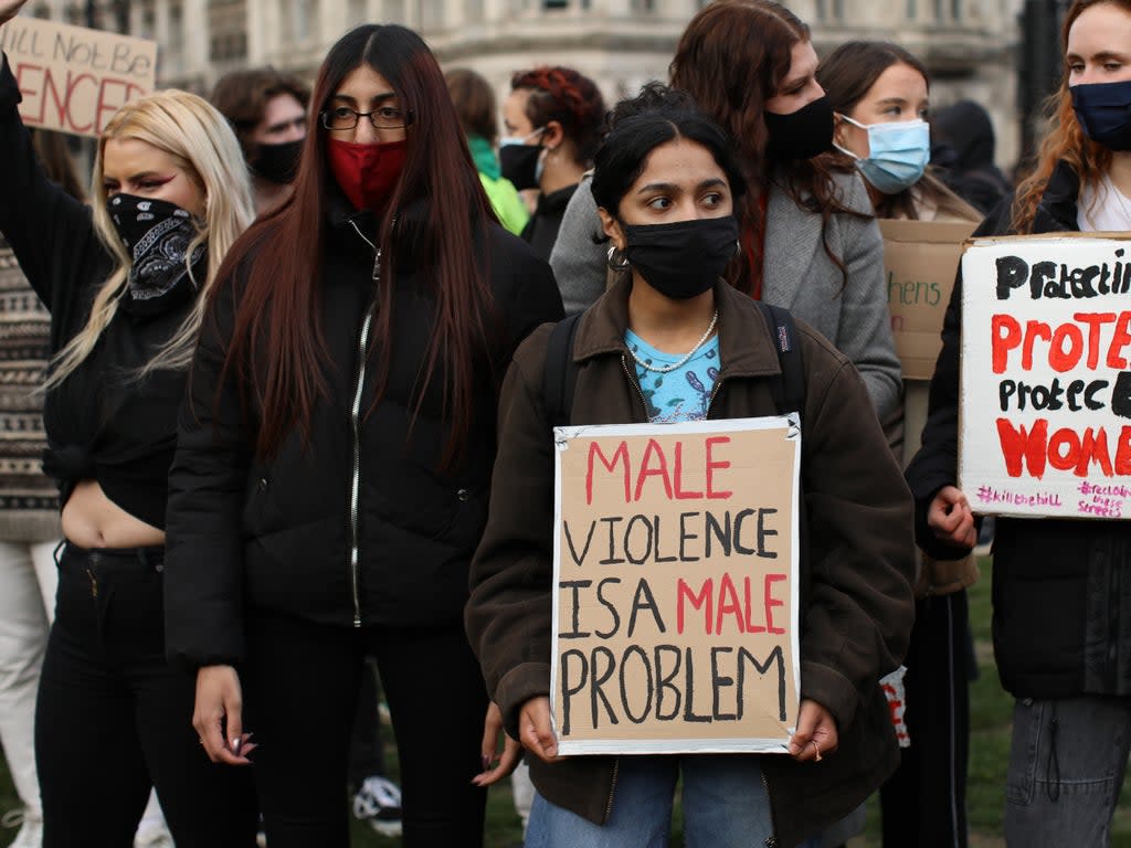 A woman holds a sign reading ‘male violence is a male problem' (Getty Images)