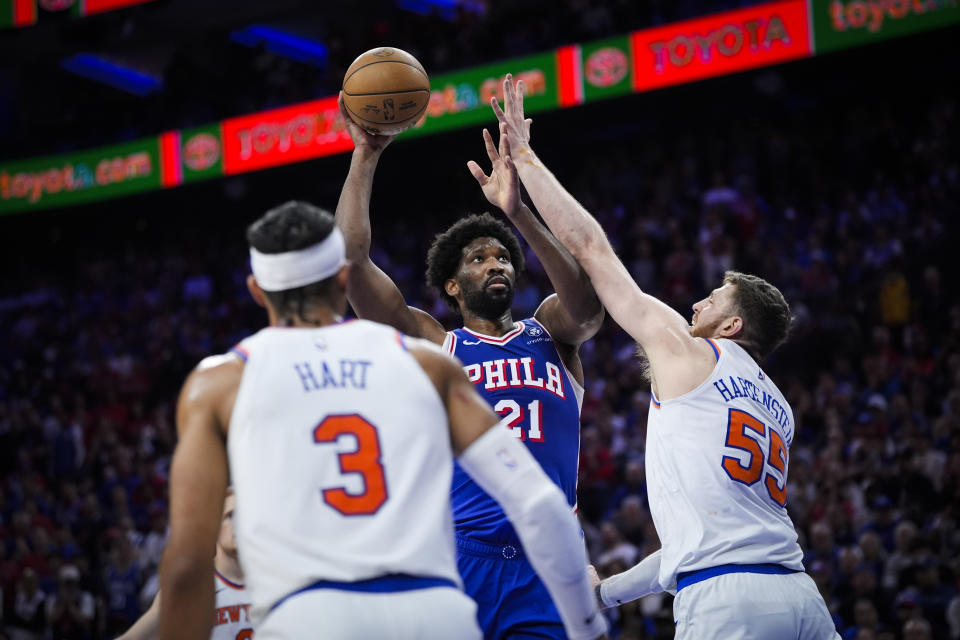 Philadelphia 76ers' Joel Embiid, center, goes up to shoot against New York Knicks' Josh Hart (3) and Isaiah Hartenstein (55) during the second half of Game 6 in an NBA basketball first-round playoff series, Thursday, May 2, 2024, in Philadelphia. (AP Photo/Matt Slocum)