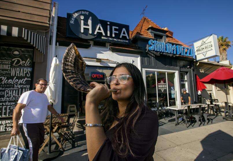 LOS ANGELES, CA-SEPTEMBER 7, 2023: Sarah Afkami, a Hollywood writer for the past decade, is photographed with her shofar on Pico Blvd. near her home in Los Angeles. Now after months on strike, she's looking to the Jewish High Holidays as an opportunity to reimagine what her life in L.A. will look like for the foreseeable future, and leaning hard on the support of her community in the Pico Robertson neighborhood. (Mel Melcon / Los Angeles Times)