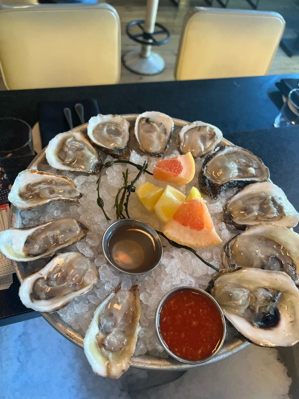 A plate of Blue Point oysters is served up at Crave Fish Bar in New York. Most oyster experts will encourage you to forgo the sauce and stick with the fruit, the better to taste the oyster. This array is presented with slices of lemon and grapefruit, which oyster expert Jeremy Benson prefers to sauce.