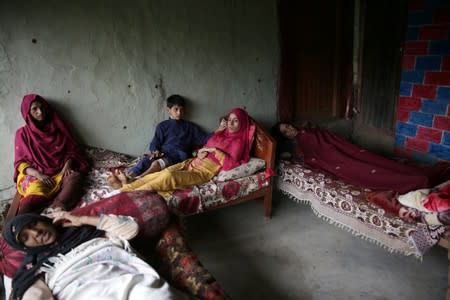 Women and a boy, who according to family were injured after a cluster bomb that looked like a toy exploded in the hands of a child at home, lay on beds in village Jabri, in Neelum Valley