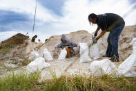 <p>Two people fill sandbags in Edgewater, Florida, ahead of Ian's arrival on Sept. 27.</p>