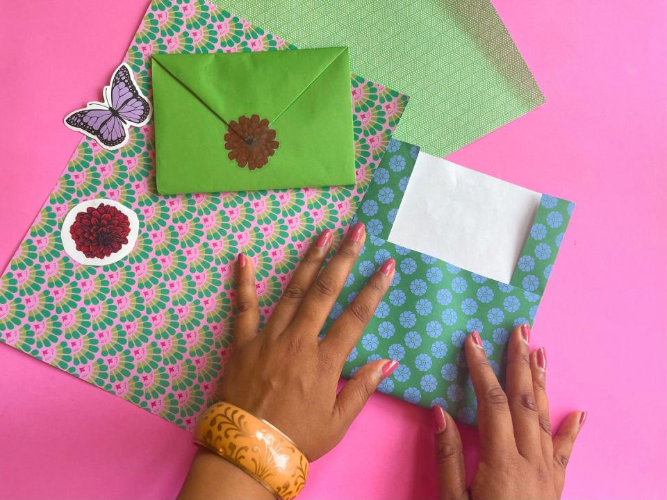 tow hands folding paper to make an envelope