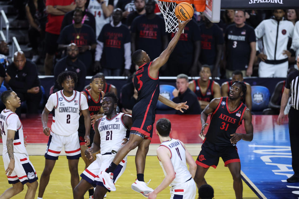 Apr 3, 2023; Houston, TX, USA; San Diego State Aztecs guard Lamont Butler (5) shoots the ball past Connecticut Huskies forward Adama Sanogo (21) during the second half in the national championship game of the 2023 NCAA Tournament at NRG Stadium. Mandatory Credit: Troy Taormina-USA TODAY Sports