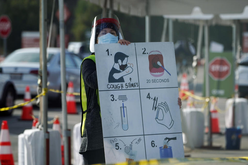 A worker gives instructions to motorists at a COVID-19 testing site Tuesday, Jan. 5, 2021, in Los Angeles. (AP Photo/Marcio Jose Sanchez)