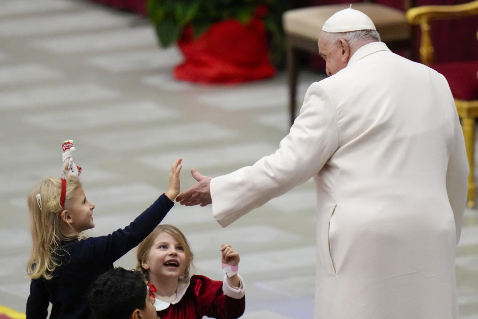 Pope Francis is greeted by children as he celebrates his birthday with children assisted by the Santa Marta dispensary during an audience in the Paul VI Hall, at the Vatican, Sunday, Dec. 17, 2023. Pope Francis turnes 87 on Dec.17. (AP Photo/Alessandra Tarantino)