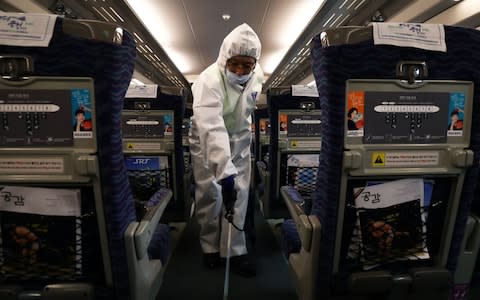 A disinfection worker sprays anti-septic solution in an train in Seoul, South Korean, amid rising public concerns over the spread of China's Wuhan Coronavirus - Credit: &nbsp;Chung Sung-Jun/&nbsp;Getty Images AsiaPac