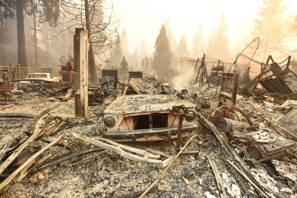 TOPSHOT - The burned remains of a vehicle and home are seen during the Camp fire in Paradise, California on November 8, 2018. - More than one hundred homes, a hospital, a Safeway store and scores of other structures have burned in the area and the fire shows no signs of slowing. (Photo by Josh Edelson / AFP) (Photo credit should read JOSH EDELSON/AFP via Getty Images)