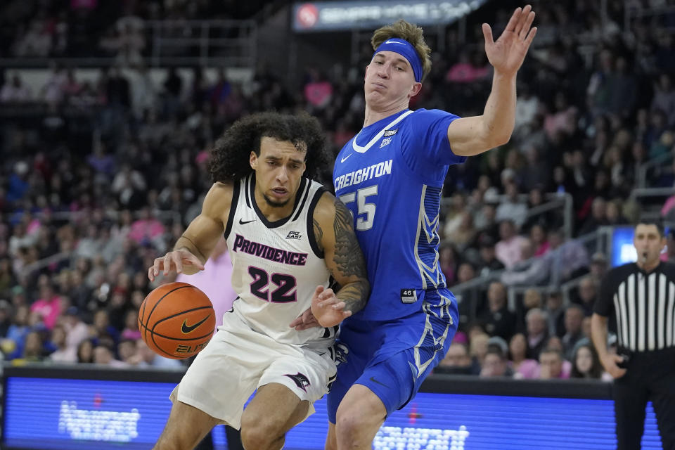 Providence guard Devin Carter (22) drives toward the basket as Creighton guard Baylor Scheierman (55) defends in the second half of an NCAA basketball game, Tuesday, Feb. 14, 2023, in Providence, R.I. (AP Photo/Steven Senne)