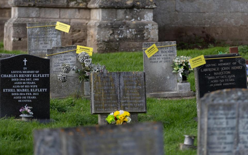 The yellow notices ask relatives to get in touch with the council, who say they have a duty of care to keep the graveyard safe