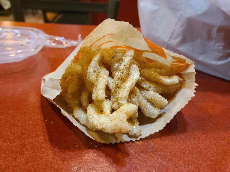 paper bag full of cinnamon twists on a red table at taco bell