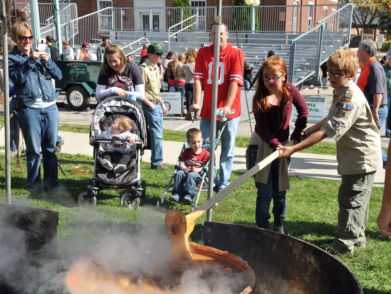 A member of Boy Scout Troop 316 of Oak Harbor and a friend churn apple butter together at a previous Apple Festival in downtown Oak Harbor.